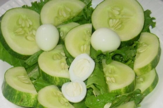 Boiled quail eggs, lettuce and pieces of cucumber in a plate